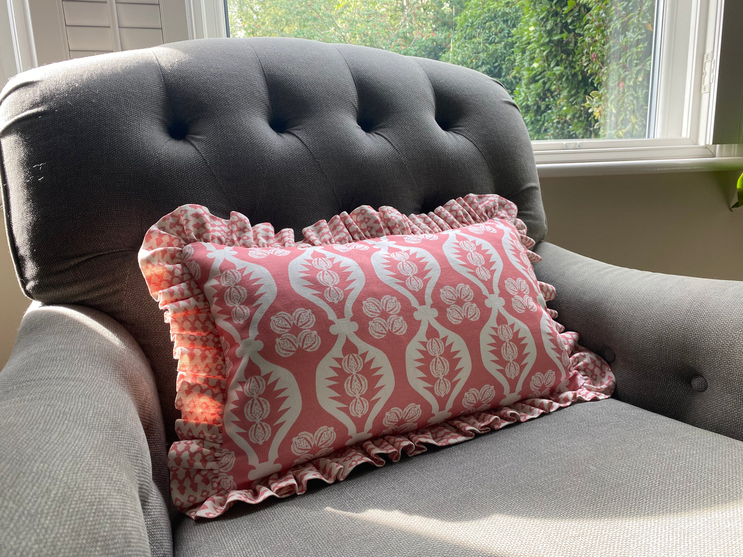 pink frilly cushion on grey chair