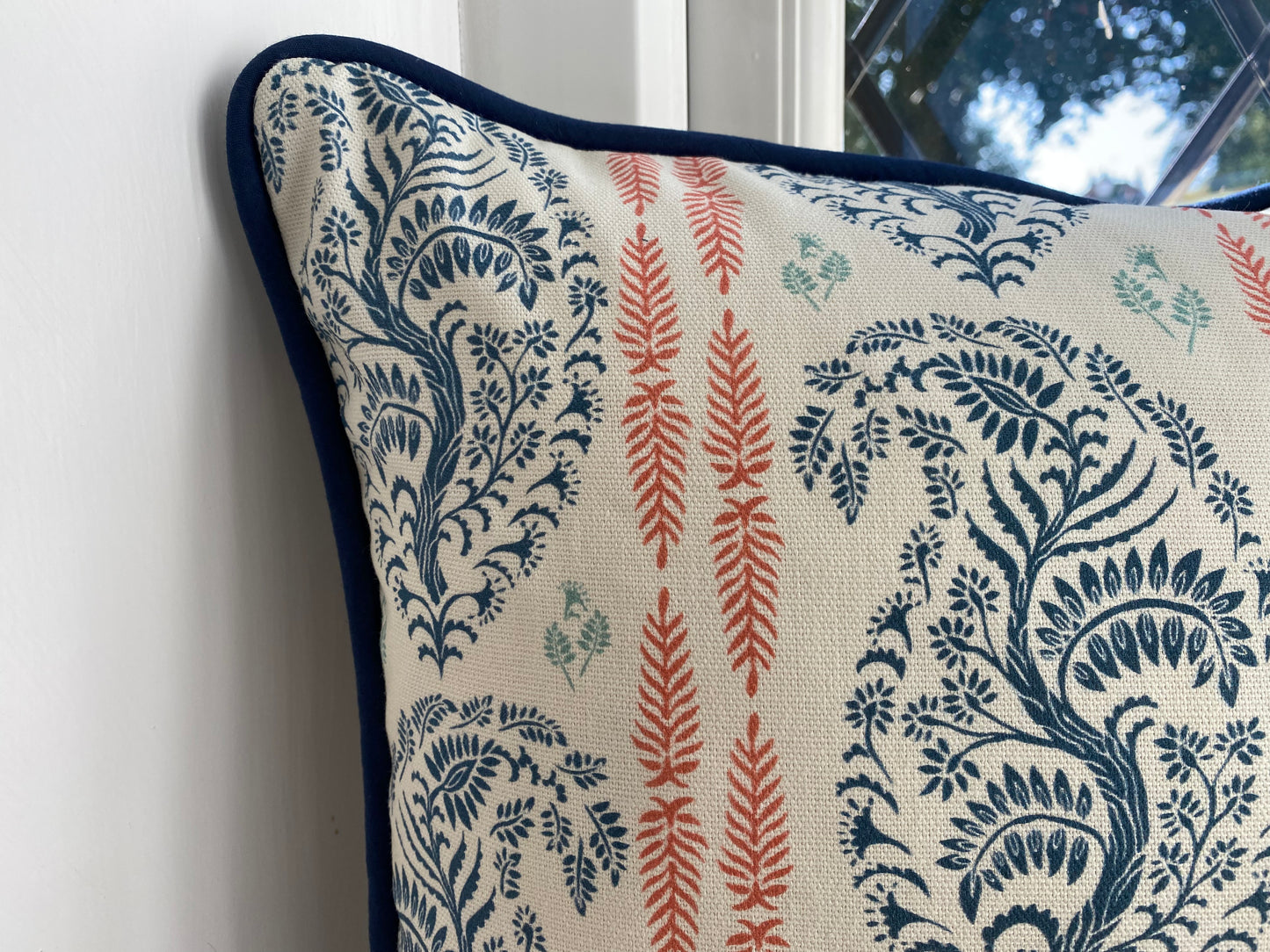 Larisa fabric blue and coral cotton piped cushion close up