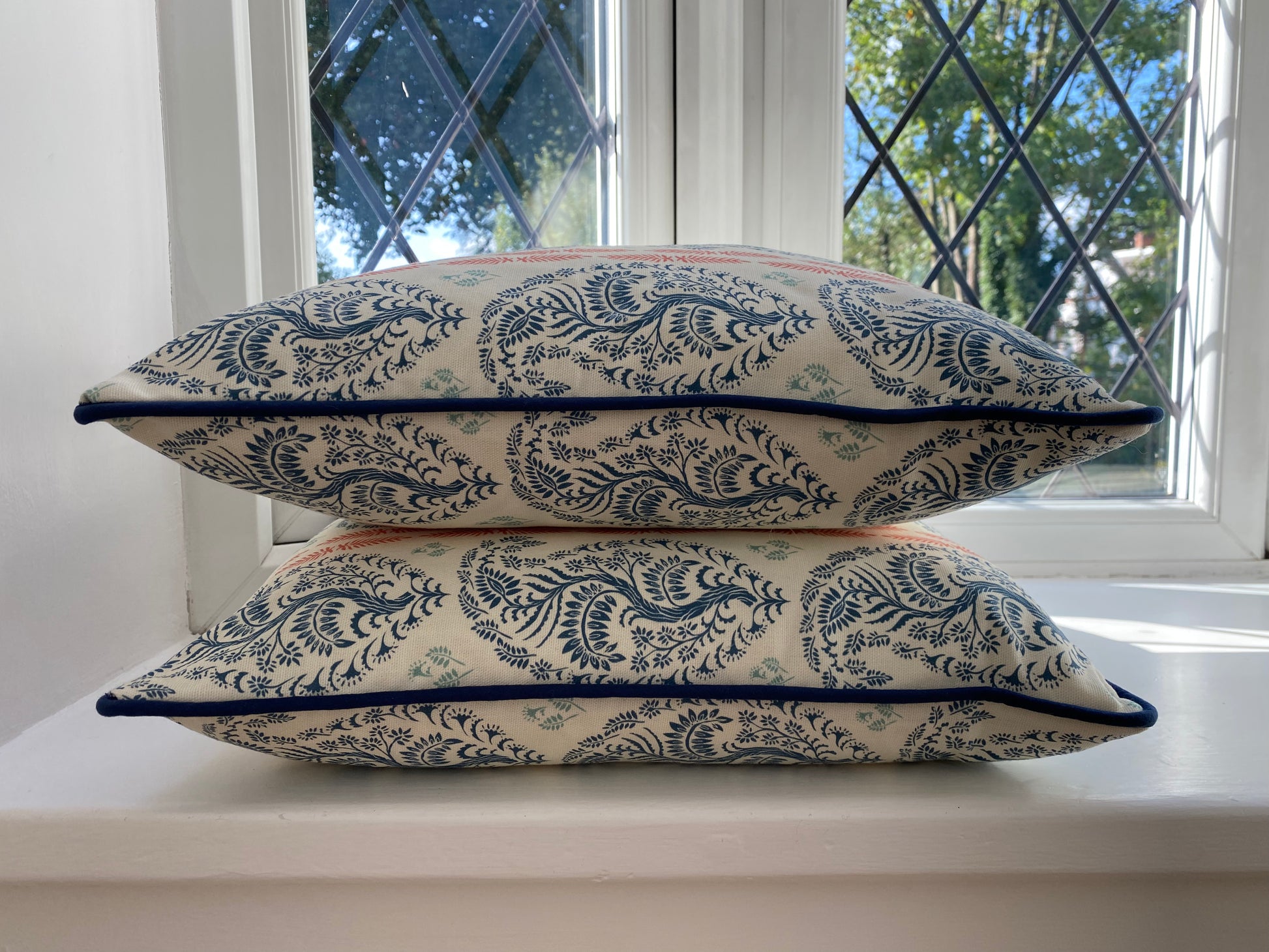 Larisa fabric blue and coral cotton piped cushions stack