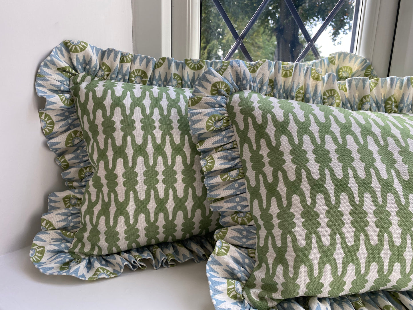 Green cushions with green and blue frill. size 45cm by 30cm. Fabric by Charlotte Gaisford. Feather cushion insert included