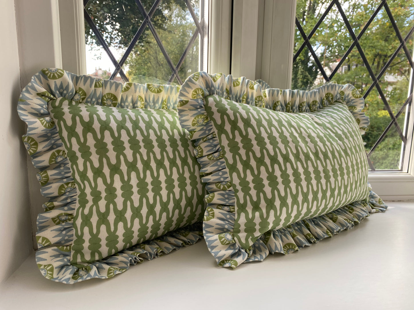 Pair of green cushions with blue and green frill. 45cm by 30cm. Feather cushion inserts included. 