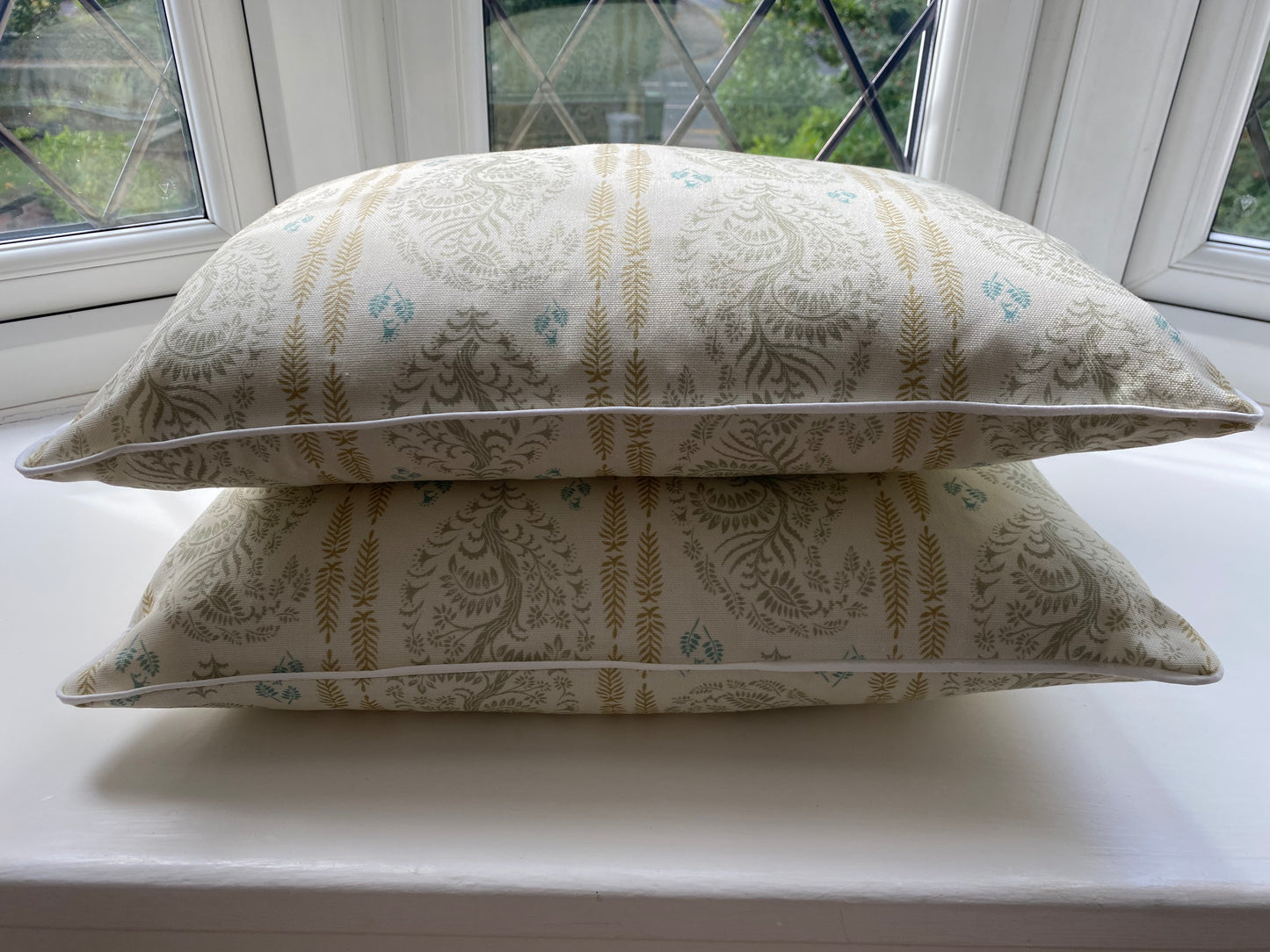 Larisa fabric sage and gold cotton piped cushions stack