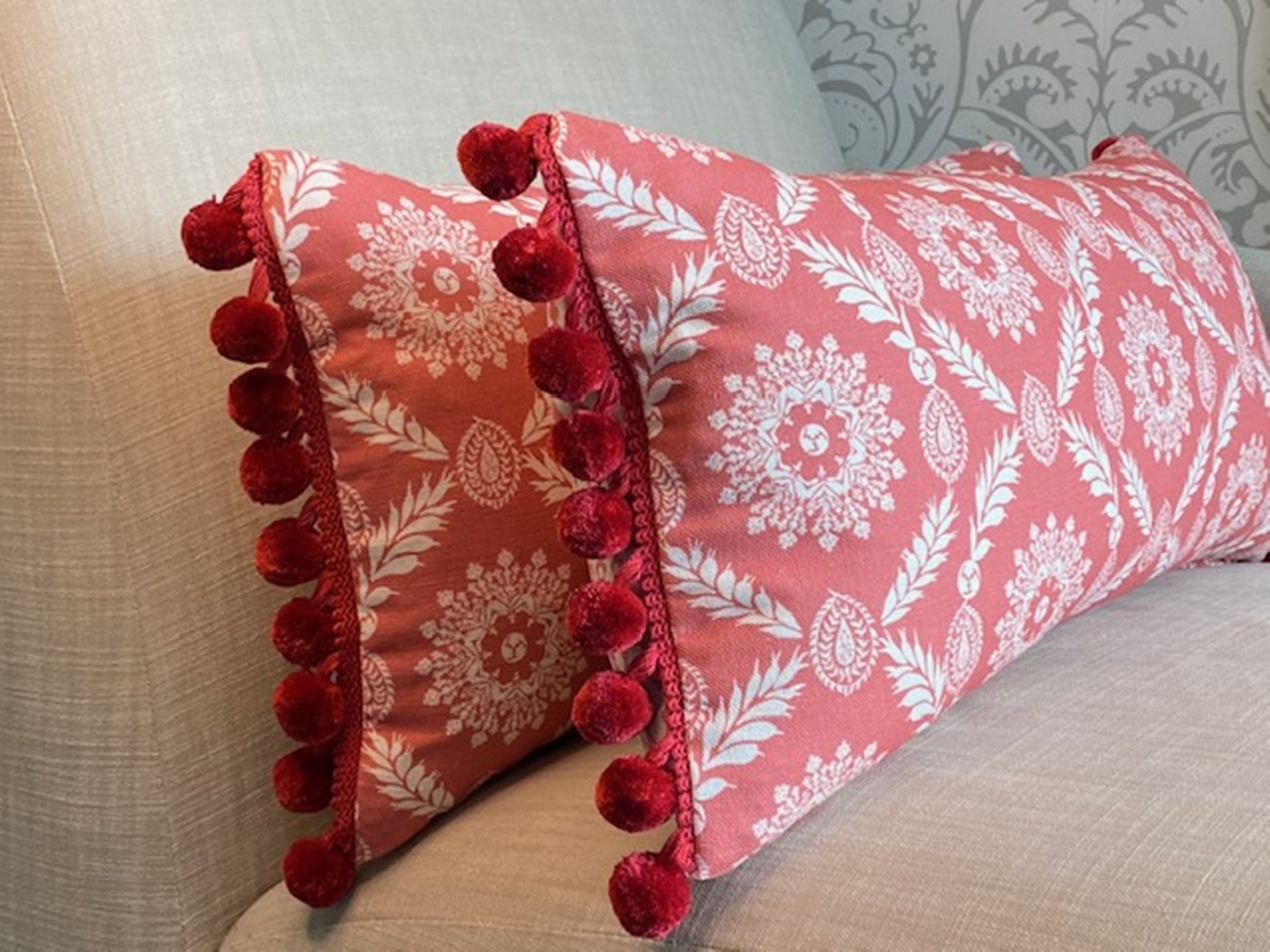 Pair of Rosie fabric red cotton cushions with red pompom trim