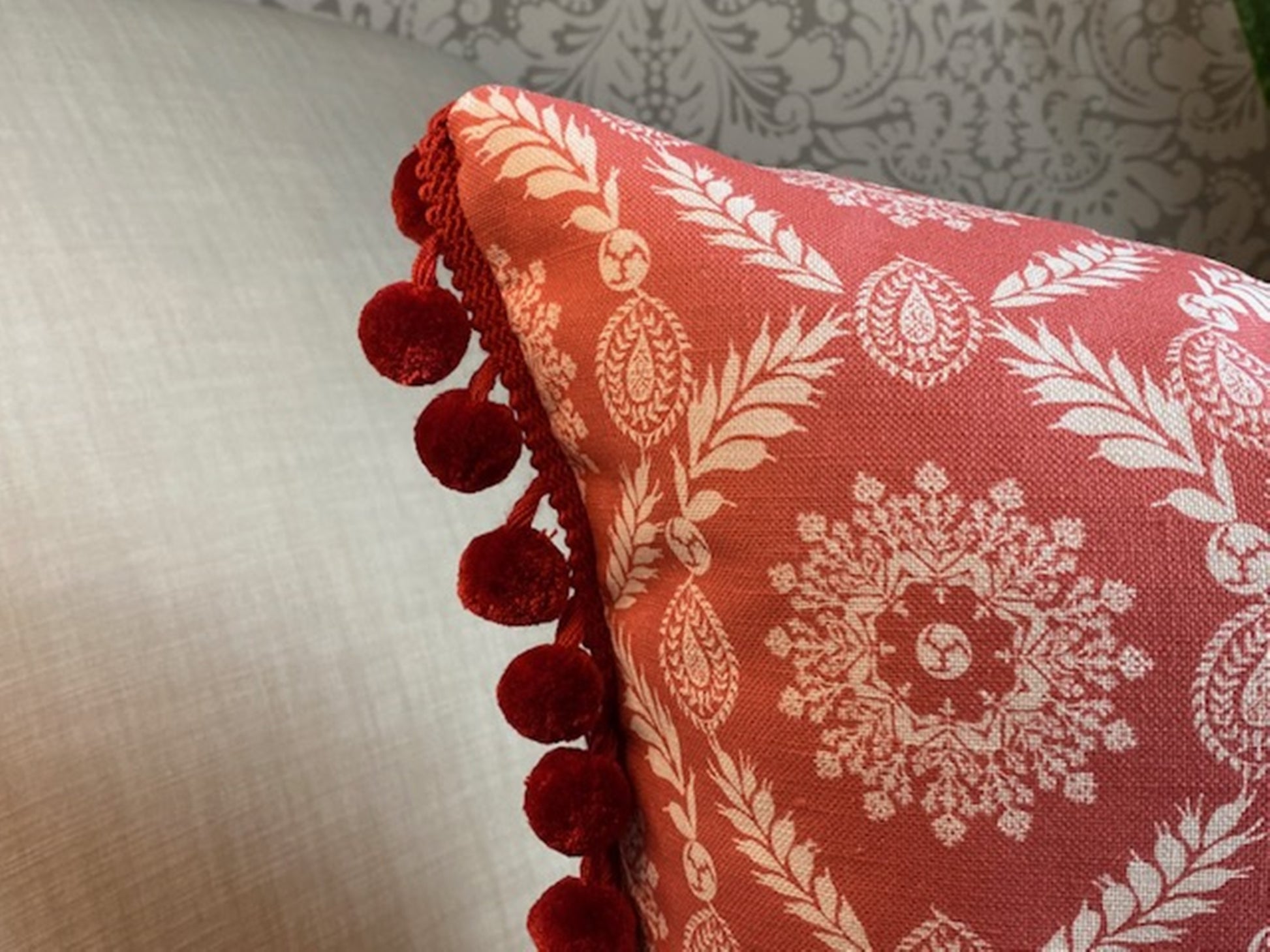 Rosie fabric red cotton cushion with red pompom trim close up