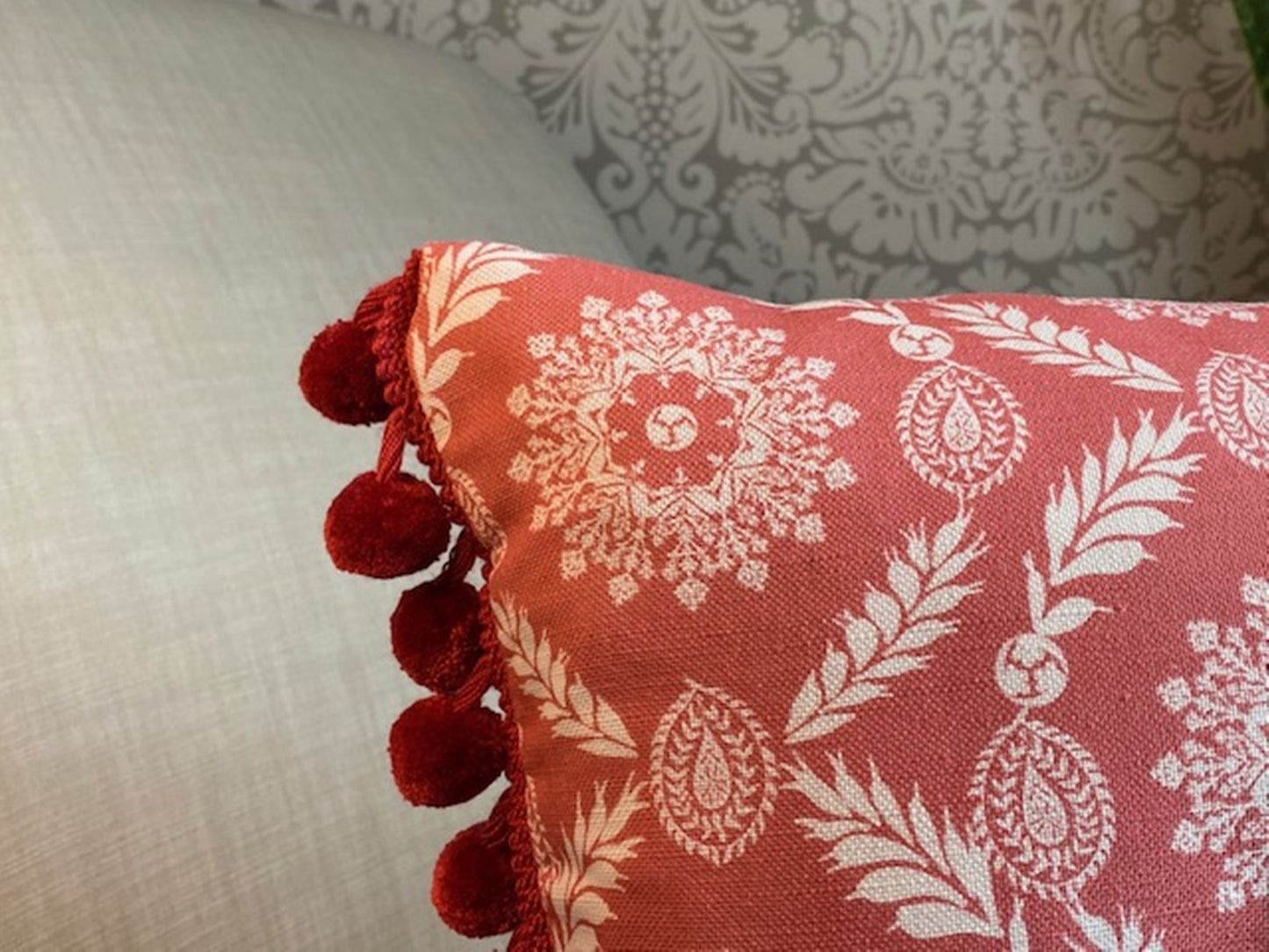 Rosie fabric red cotton cushion with red pompom trim close up