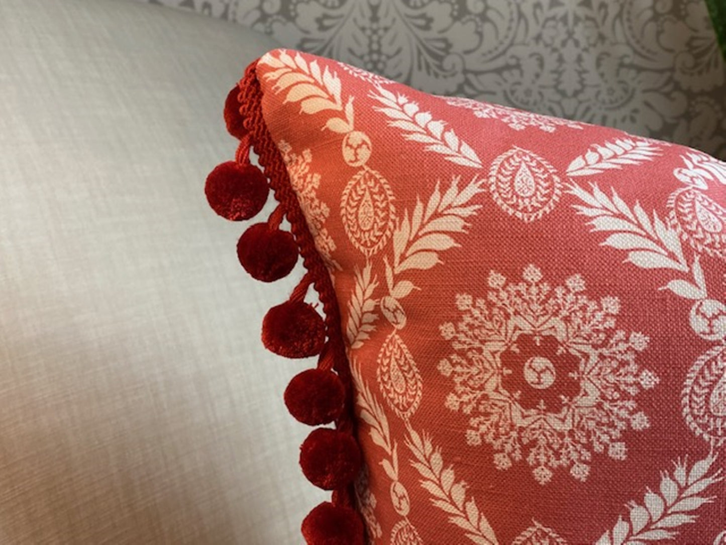 Rosie fabric red cotton cushion with red pompom trim close up